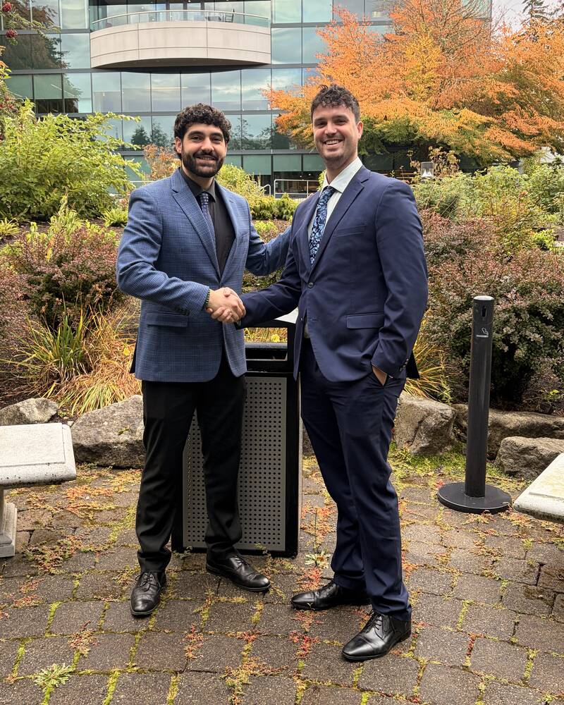 Two Iron Peak Collective professionals shaking hands outside an office building