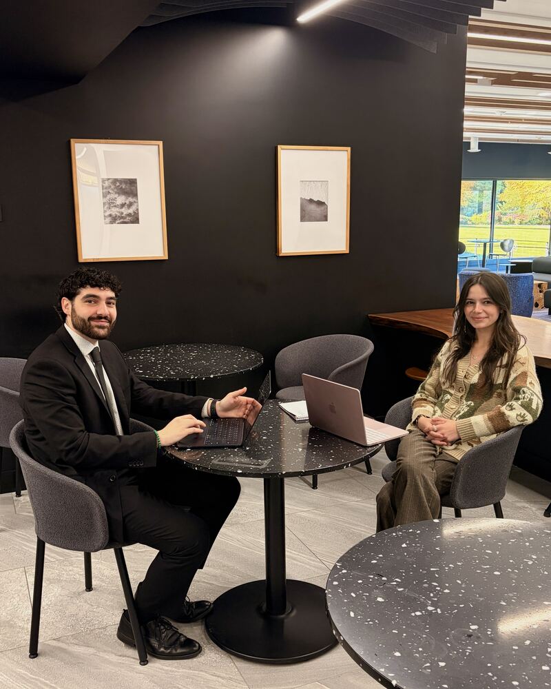 Two Iron Peak Collective team members meeting at a table with laptops