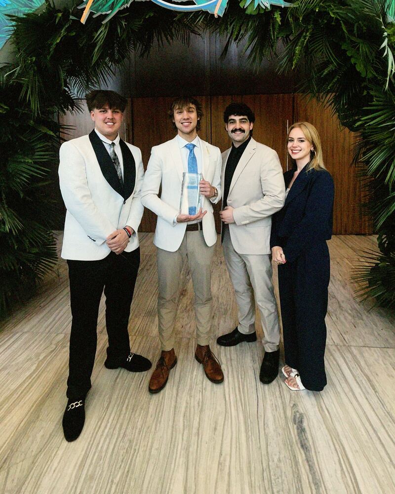 Four Iron Peak Collective team members holding an award at an event