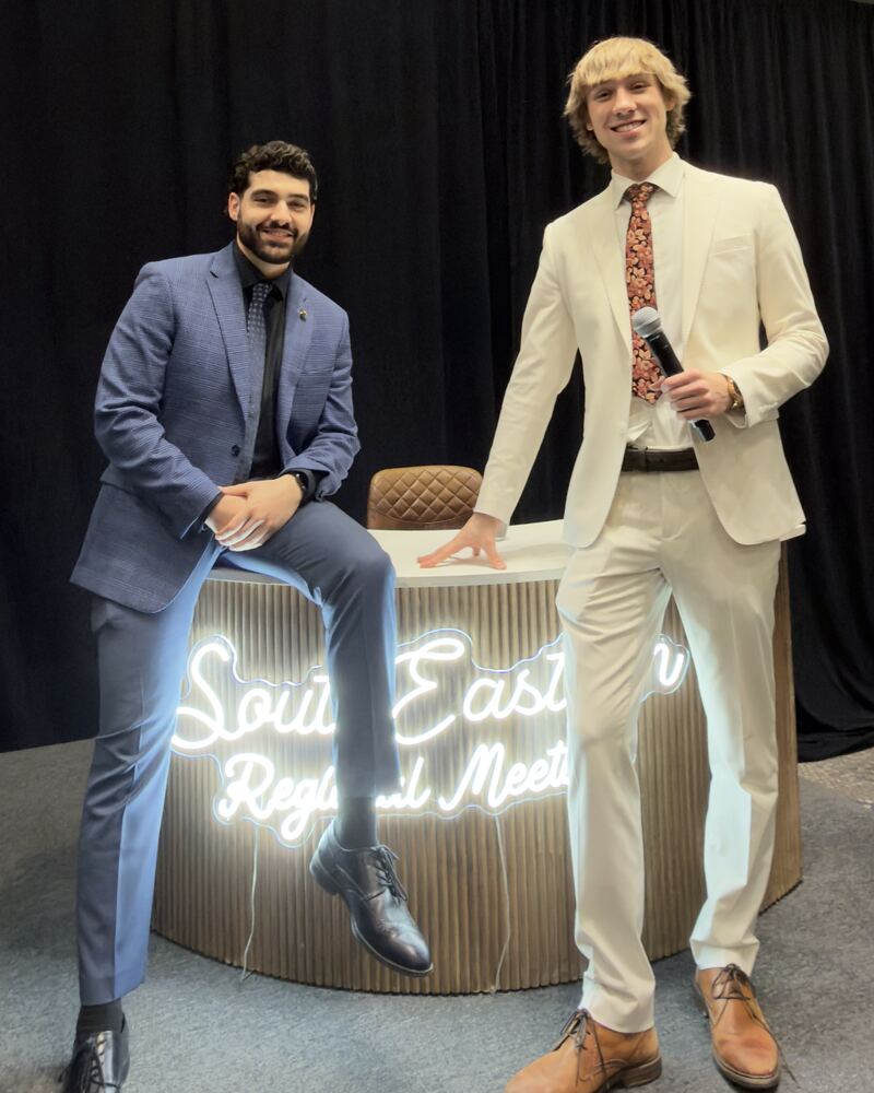 Two Iron Peak Collective team members on stage at a regional meeting